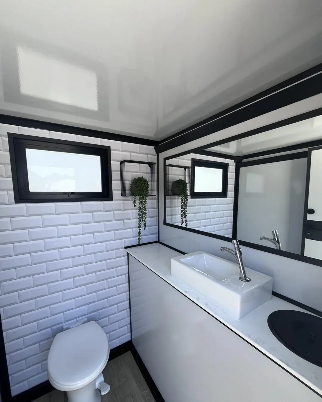 Restroom trailer interior with subway tile, mirror and vessel sink